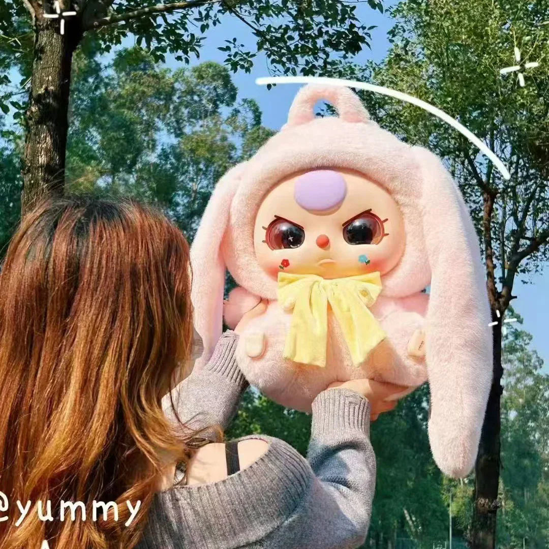 Person holding pink plush rabbit bag from Myfunboxs, outdoor park trees